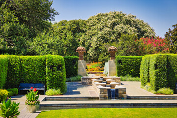 A beautiful garden with a fountain and a bench