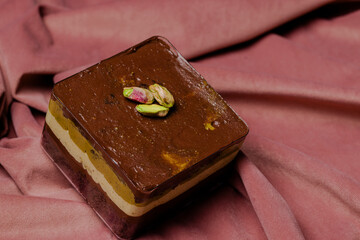 Layered Dessert with Pistachios: A delicious treat! Indulge in the rich, creamy layers of this delightful square dessert topped with pistachios.