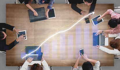 A dynamic team meeting in a modern office showcases diverse professionals using digital devices to analyze data and collaborate effectively. Impute