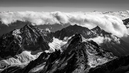 majestic mountain landscape with rolling clouds captured in serene black and white during daylight hours