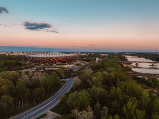 Obraz premium Warsaw city center and skyscrapers in the background Vistula river and Swietokrzyski bridge. Sunset Warsaw aerial view.