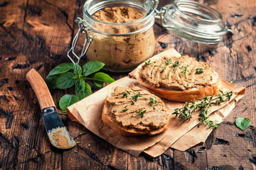 Fresh homemade chicken liver pate on bread over rustic background