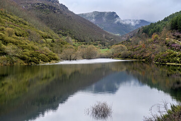 Serene view of Compuerto Reservoir surrounded by mountains in Palencia