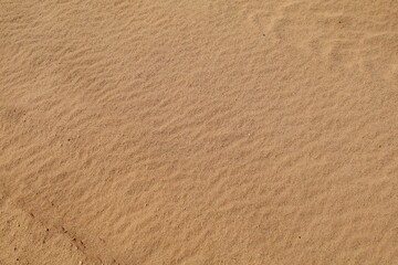 sand texture - background of desert sand dunes. Beautiful structures of sandy dunes. sand with wave from wind in desert - Close up