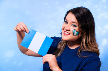 Smiling Woman with Artistic Makeup Holding the Flag of Guatemala on Blue Background