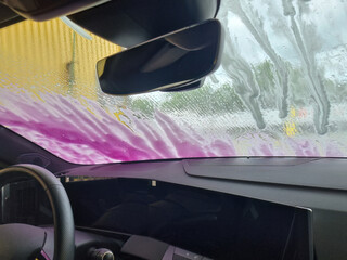 View from car interior during soap rinse at car wash
