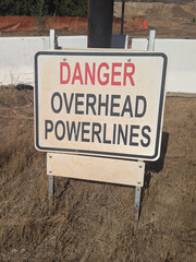 Sign reading Danger Overhead Powerlines at a construction site