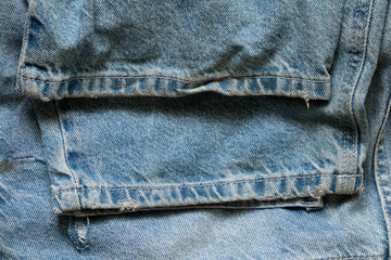 Women's jeans folded with creases and seams on the bottom of the pants as a background for design and fashion