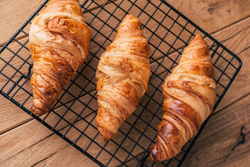 fresh croissants on wooden background