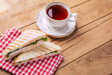 Sandwich and tea on wooden background
