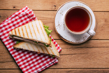 Sandwich and tea on wooden background