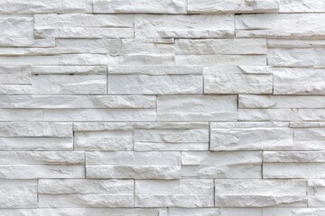 White stone wall textured rectangles laid horizontally various lengths uneven rough surface mortar not visible