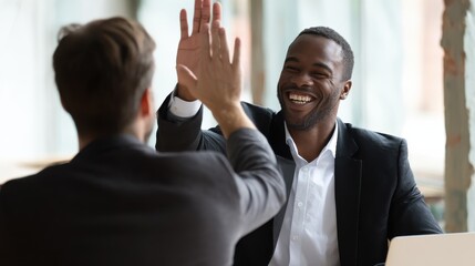Indian happy smiling multiracial professional ceo businessman giving highfive to business partner after financial acquisition bank bargain contract at office. High five concept. Over shoulder view.,