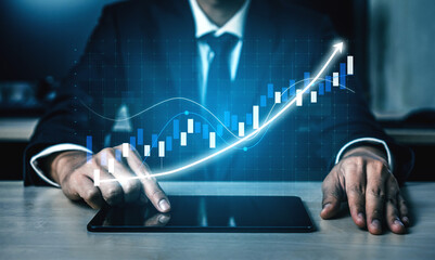 A businessman focuses on financial data displayed on a tablet, with a dynamic stock market graph...