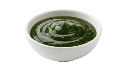A bowl of vibrant green spinach dip with a glossy sheen on a stark black and white background shot close up on transparent background