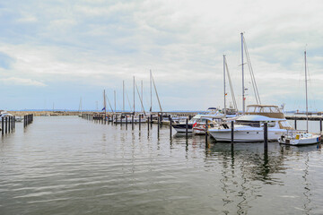 Obraz premium Yachts Docked in Harbor Marina Under Cloudy Sky - Travel and Leisure Concept