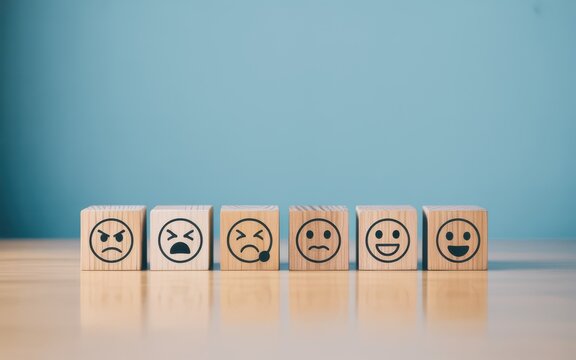 Faces of emotion wooden blocks display a spectrum of human feelings from anger to joy, reflecting user sentiment