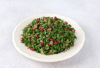 Levantine vegetarian Tabbouleh salad with quinoa, tomatoes, pomegranate, parsley, lemon and dressing