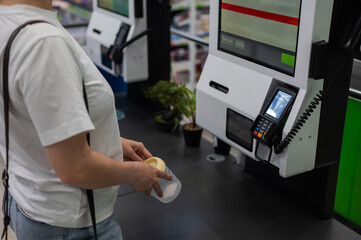 A woman scans items at a self-checkout. 