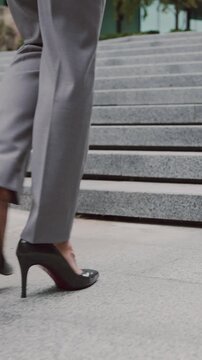 Businesswoman in high heels walking stairs outdoors