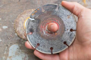 Close-up of a Rusty Circular Saw Blade Held in Hand Industrial Tool Wear and Tear