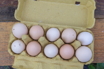 Ten Organic Eggs in a Recycled Carton on Wooden Table - Farm Fresh Top View