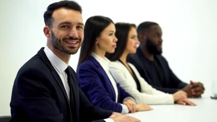 A diverse group of professionals sitting in a line at a table
