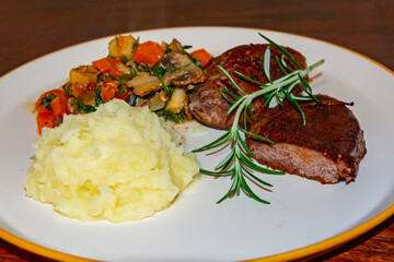Deer steak with mushroom-vegetable ragout and mashed potatoes