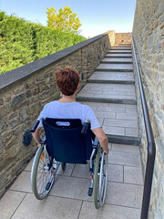 mujer con discapacidad de movilidad en silla de ruedas ante un obstaculo urbano para poder acceder a un espacio público minusválida IMG_1545-as25