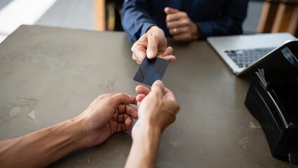 Customer Handing Credit Card to Shopkeeper at Counter