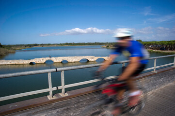 Blurred photo of a man cycling on a street, capturing motion and urban life.