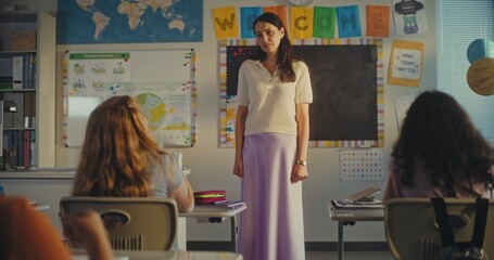 STEM Class: Beautiful Female Teacher Educating Geography to Elementary School Students in Modern Classroom, Listens to the Student's Answer. Smart Diverse Kids Sitting at Desks, Studying Science.