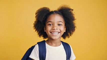 Cute African American child 7 years old with backpack posing on solid yellow background with copy space and smiling. Back to school 