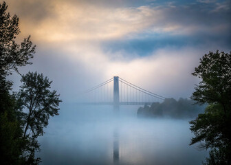Obraz premium A bridge enveloped in mist or fog, creating a serene and mysterious scene