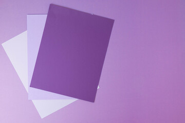 Three sheets of blank paper, monochromatic color scheme, violet purple background.