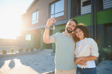 Happy couple showing keys to their new house