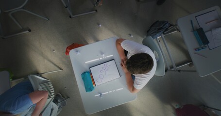 Classmates Bullying Stressed Elementary School Boy Sitting at Desk and Crying: They Laughing and Throwing Papers. Boy Suffering from Peer Harassment, Emotional and Physical Abuse. Rotating Top View.