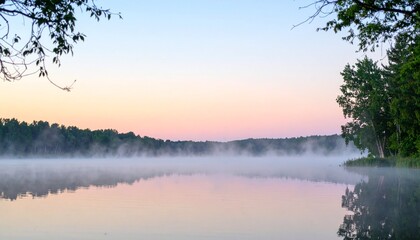 Obraz premium 夜明けの静かな湖に霧が漂い、淡い水彩風の樹木とパステル色の空が織りなす穏やかな自然風景とテキスト空間を捉えた写真