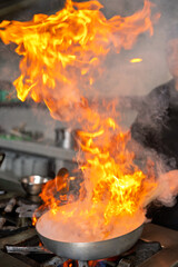 Chef cooking peruvian food with fire in a restaurant kitchen