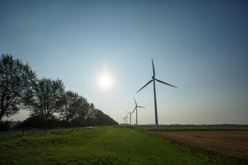 Wind turbines generate renewable energy in an open landscape during a clear afternoon
