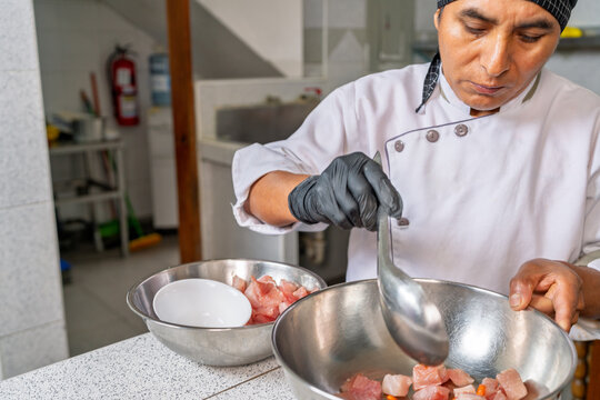 Peruvian chef preparing traditional ceviche in restaurant kitchen - Powered by Adobe