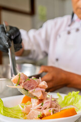 Chef preparing traditional peruvian ceviche in restaurant kitchen