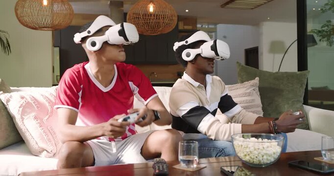 Diverse male friends initiating VR session by leaning forward gripping controllers in living room