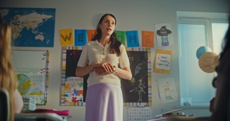 STEM Class: Dolly Shot of Female Teacher Starting Lesson, Educating Renewable Energy to Elementary School Students in Classroom. Smart Diverse Kids Studying Ecology, Listen to Lecture. Slow Motion.