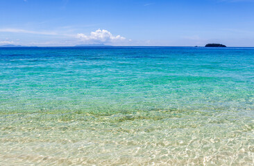 Koh Adang, Thailand. Turquoise Andaman sea meets sandy beach under blue sky. Beautiful tropical sea landscape.