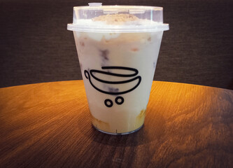 Butterscotch Sea Salt Latte drink, delicious coffee latte drink with crumbs sprinkles. Above wooden brown table.