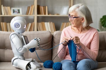 Robot helping senior woman knitting together on sofa future technology concept image