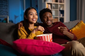 Couple watching movie at home with popcorn happy african american couple on sofa
