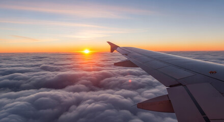 Obraz premium Wide shot from an airplane window of the wing flying over a sea of clouds during a beautiful golden sunset, creating a sense of travel. 