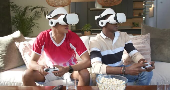 Seeing game start, Diverse male friends playing VR game while wearing headsets on sofa at home